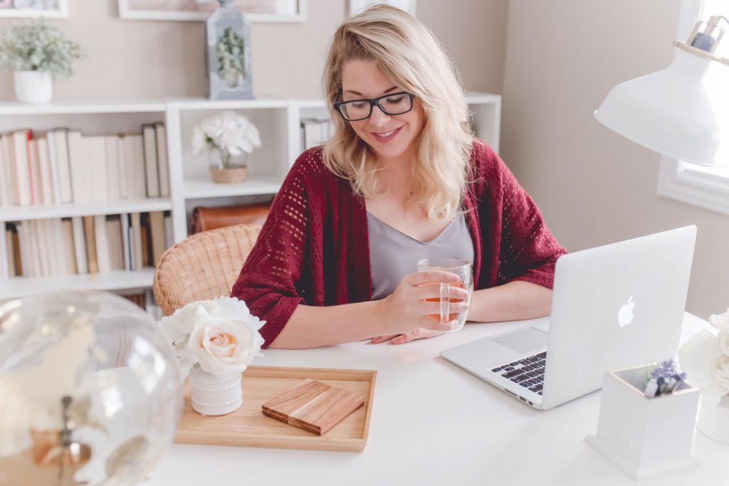 Jeune femme freelance qui travaille à domicile sur son ordinateur portable