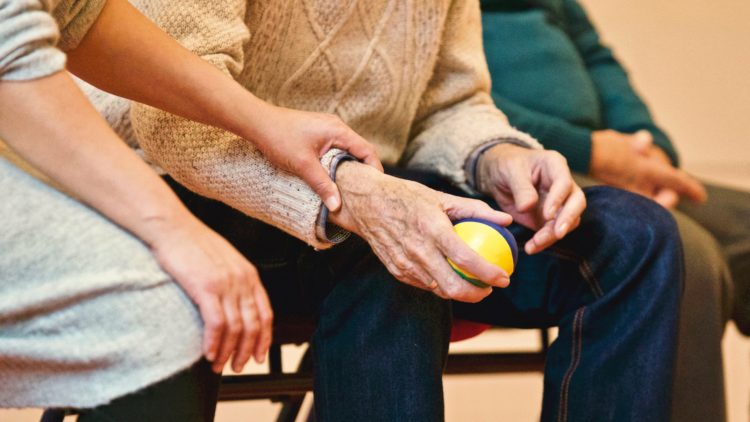 Personne qui tient le poignet d'une personne âgée