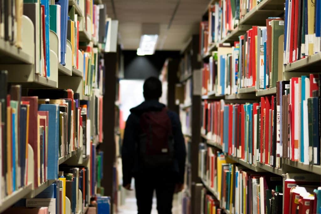 bibliothèque avec homme de dos au milieu